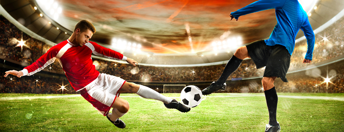 jogador de vermelho disputando a bola com outro jogador vestido de azul